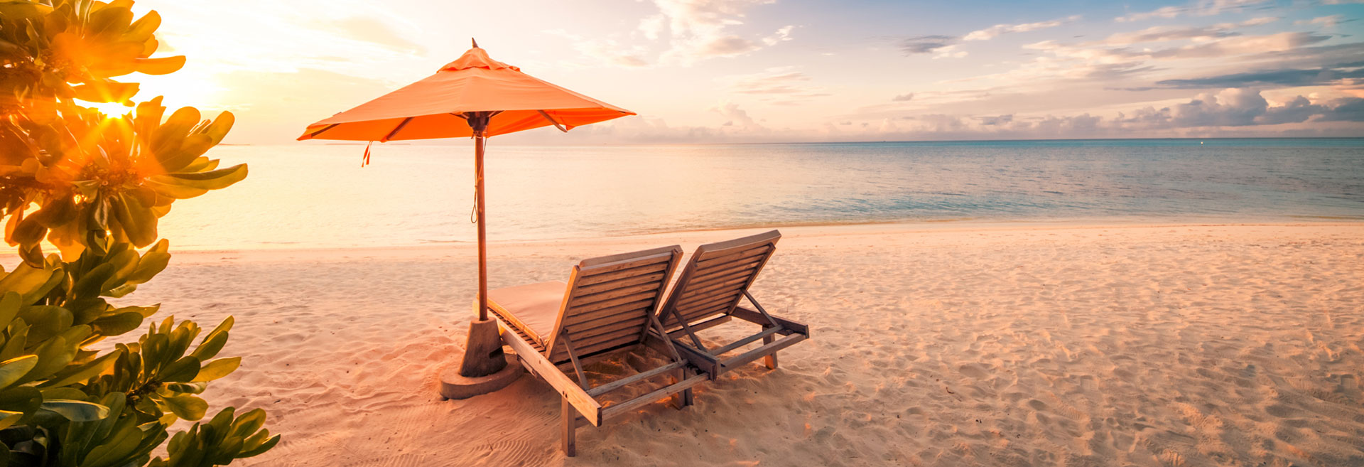 Wooden Beach Lounges with orange umbrella at the seaside escape of The Residences at The St. Regis Longboat Key Resort