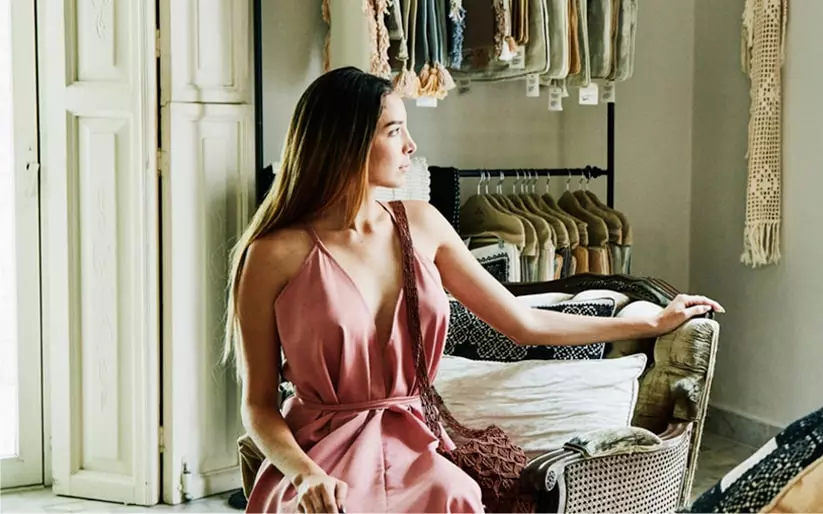 Woman in pink dress sitting in a chair at an upscale clothing store in Sarasota
