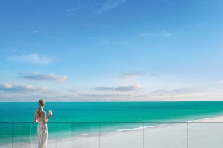 Woman on patio looking at ocean at The Residences at The St. Regis Longboat Key